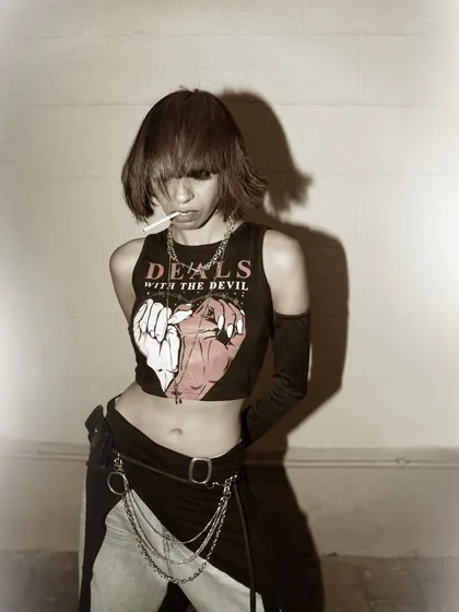 A gritty, vintage-inspired shot with a rock-and-roll aesthetic. The sepia tone and hard flash create a retro vibe, perfect for alternative fashion or music-related branding.