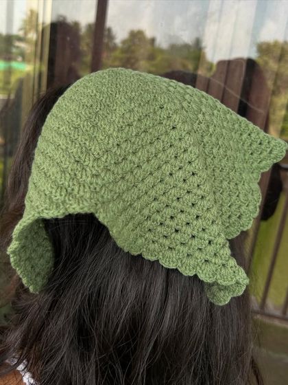 The back view of the olive green bandana, showing how it tapers to a point. The scalloped edge adds a delicate finishing touch.