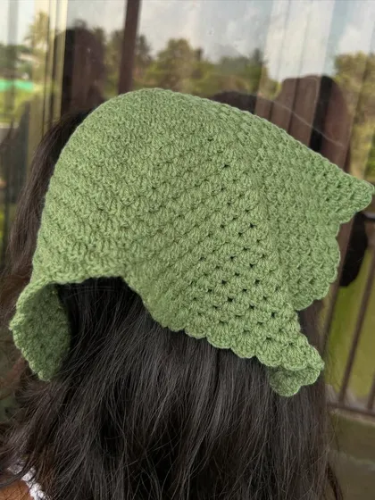 The back view of the olive green bandana, showing how it tapers to a point. The scalloped edge adds a delicate finishing touch.