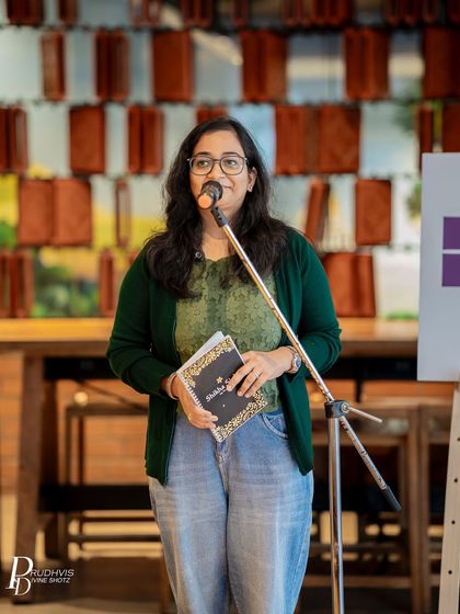 A performer holds her notebook, ready to share her work. The simple act of standing before a mic can be a powerful moment of self-expression.