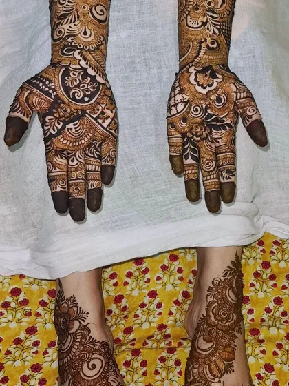 A lovely shot of matching hand and feet henna. The designs are coordinated, with similar motifs and patterns used on both to create a cohesive bridal look.