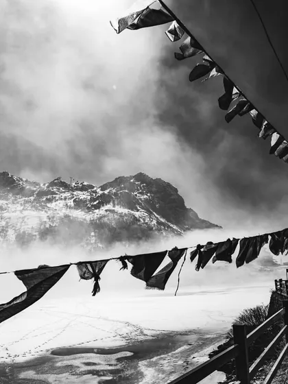 prayer flags against a snowy, misty mountain. the texture and contrast in this black and white photo influence my approach to creating visually engaging interfaces.