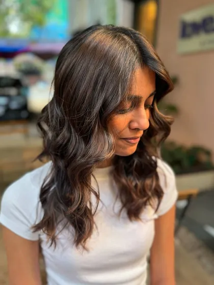 A side view of this bridal brunette hair. The color is subtle and elegant, and the soft waves add a romantic touch.