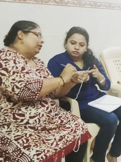 Focusing on the details is key. In this photo, I am showing a student the correct way to hold the crochet hook and manage yarn tension, two fundamental skills for creating neat and even stitches.
