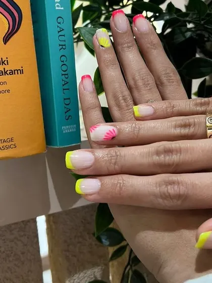 Nails that make hearts flutter! This neon French manicure with abstract floral details is a bold and playful summer look.