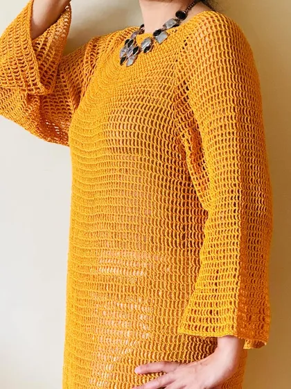 The detail on the bell sleeve of my mustard crochet dress is one of my favorite parts. I designed the sleeves to have a gentle flare, adding a bit of retro-inspired elegance to the overall silhouette.