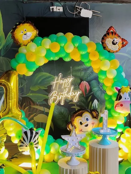 We bring kids' party themes to life. This jungle-themed first birthday party features a vibrant balloon arch, fun animal character foils like a lion and monkey, and a large number '1' foil to mark the special day.