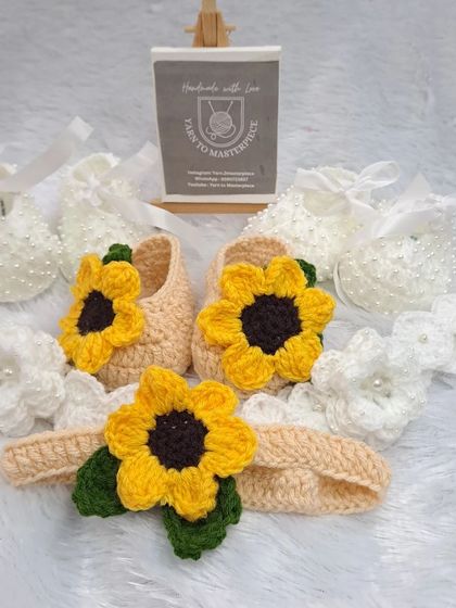 A beautiful display of some of my favorite baby shoe designs. This photo shows a cheerful sunflower-themed booties and headband set alongside a classic white pair decorated with delicate pearls.