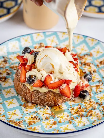 An action shot like this is pure gold for social media and menus. Capturing the perfect pour creates a dynamic, mouth watering image that makes customers feel the texture and richness of the dish before they even order.