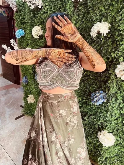 A full-length shot showing how a dark henna stain complements the entire bridal look.