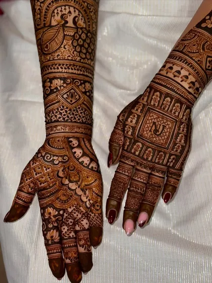 This bridal design features a personalized initial 'N' on one palm and a majestic peacock on the other arm. The combination of personalization and traditional art makes it truly special.