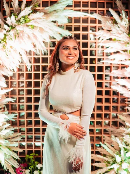 The bride posing against a beautiful backdrop, her modern half-updo with waves looking stunning.