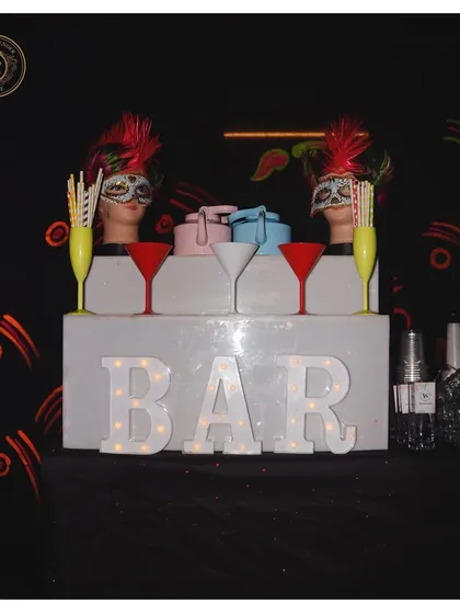A masquerade-themed bar setup, complete with mannequin heads in masks and a sleek, modern design. We love creating an air of mystery and fun.