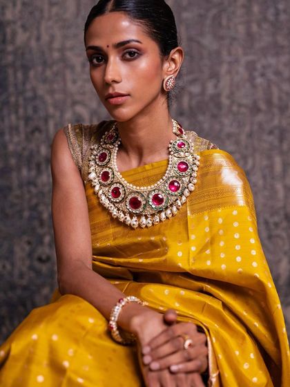 A portrait of the model in the yellow Kanchipuram saree, her confident gaze reflecting the power and beauty of a traditional bride.