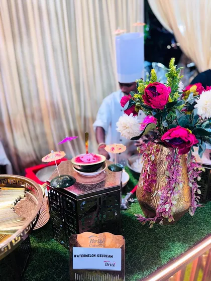 A beautifully presented Watermelon Ice Cream, served in a hollowed-out watermelon half, garnished with flowers.