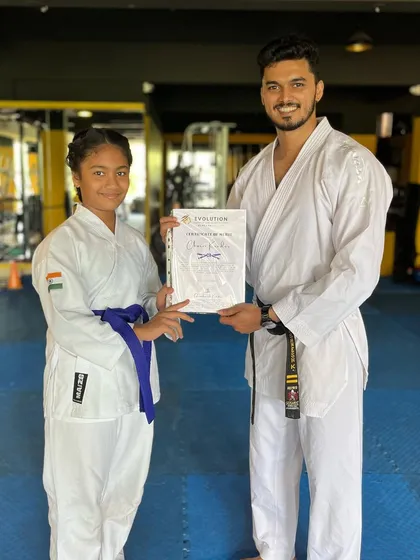A student receives her certificate, a tangible reward for her hard work and dedication to karate.