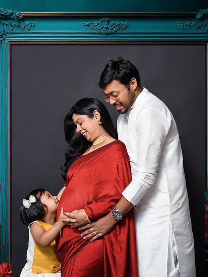 A heartwarming family moment during a traditional maternity shoot. The couple's older daughter gently kisses the baby bump, beautifully capturing the love and excitement of a growing family.