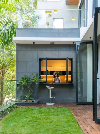This kitchen at the 'Nest' residence in Odion Rainbow Retreat features a unique breakfast counter that opens directly to the garden. It’s a design choice that blurs the line between inside and out, allowing for a morning coffee with a view and filling the space with natural light.