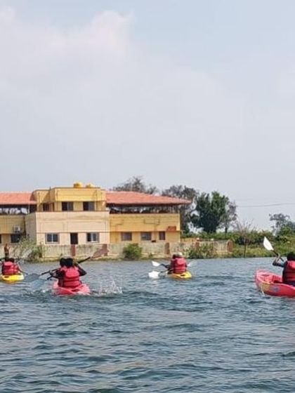 Kayakers paddle towards our training center in Ambigarahalli after a session on the water.