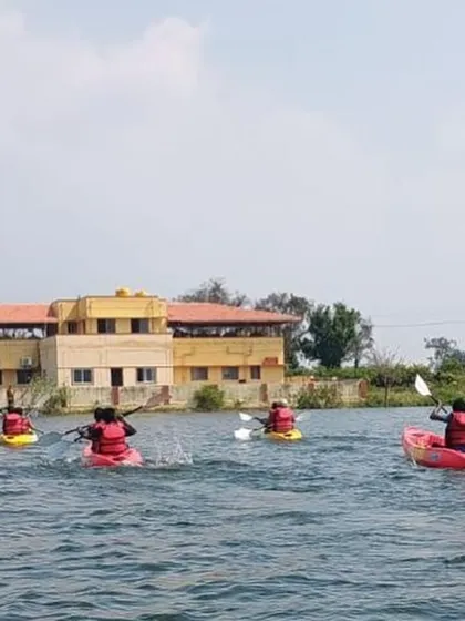 Kayakers paddle towards our training center in Ambigarahalli after a session on the water.