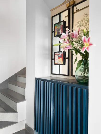 We introduced a splash of deep blue with this fluted console table in the foyer. The vertical lines create a sense of height and texture, while the dark top provides a strong contrast. It is a simple yet powerful piece that adds personality to a transitional space.