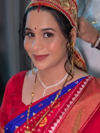 A close-up portrait highlighting the soft eye makeup, rosy cheeks, and the traditional Dejhoor earrings.