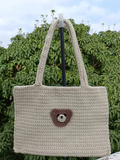 A custom tote bag featuring a cute bear face applique. This is a great example of how I can add personalized touches to my bag designs.