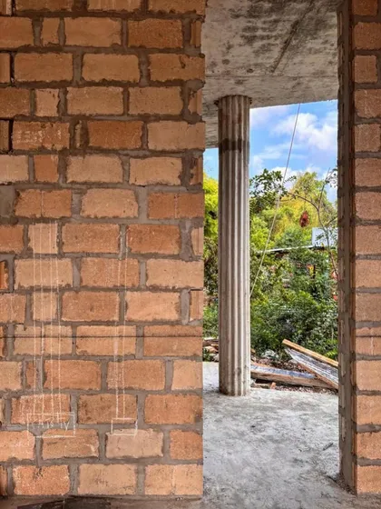 A detail of the blockwork and a fluted concrete column at Kizikula. This image shows the raw material palette of the building's shell before the finishing layers are applied.