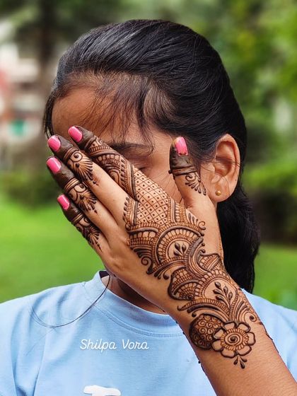 A client showing off her modern Arabic-style design, which focuses on the wrist and one side of the hand.