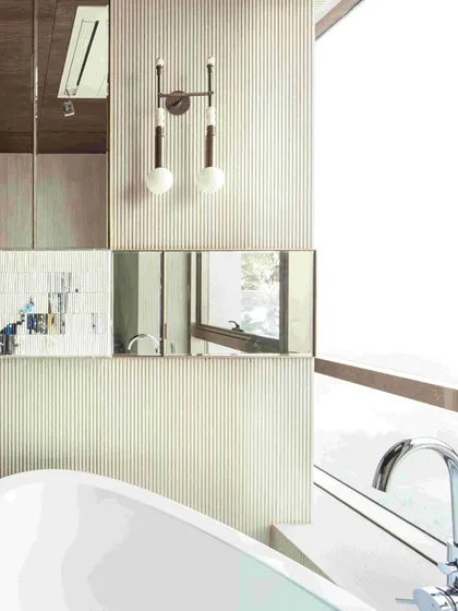The daughter's bathroom at 'The 42, Kolkata', featuring a freestanding Kohler bathtub and a custom vanity. Delicate paper art by Ashoka Acharya adds a touch of creative charm.
