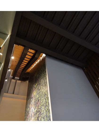 A detail shot focusing on the structural and material details of a commercial project, including glass railings and exposed ceiling beams.