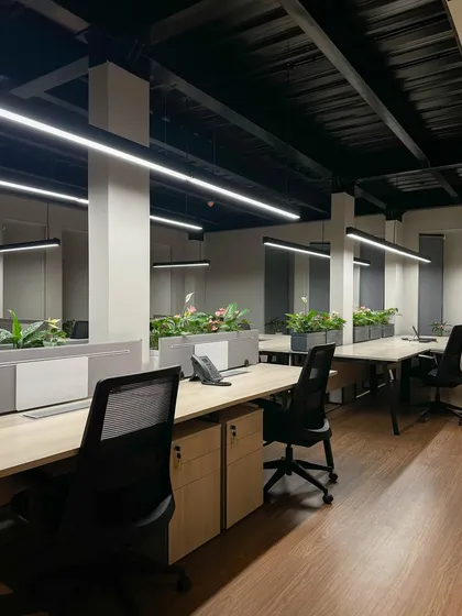 An open-plan workspace designed for collaboration and well-being. We integrated biophilic design principles with planters on each desk bank, paired with linear overhead lighting and an exposed industrial-style ceiling.