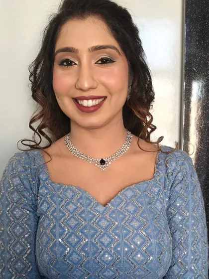 A simple and elegant HD makeup look. The hair is styled in a classic half-updo with curls, a versatile choice for any party or event.