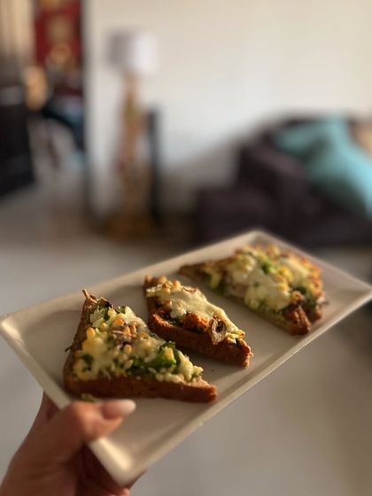 A healthy and tasty crispy ragi loaf toast. It's topped with grated broccoli, chopped zucchini, capsicum, boiled mushrooms, and a sprinkle of low-fat cheese for a perfect evening snack.