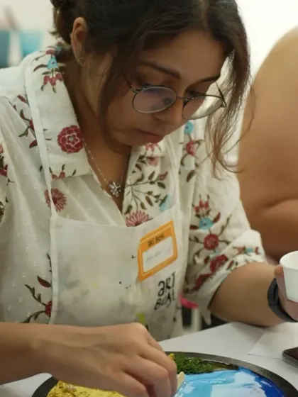 A participant carefully works on her resin beach art during a corporate workshop. Art is a great way to de-stress and bond with colleagues.