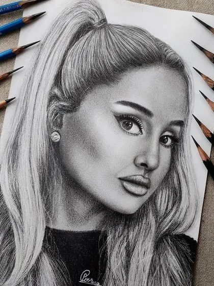 A hyper-realistic graphite portrait of Ariana Grande. I used a range of pencils from light to dark to create depth and capture a soft, yet striking expression.