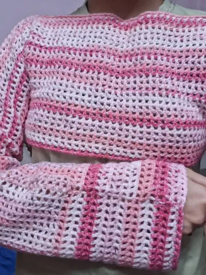 A close-up of the fitted cuff and sleeve of the pink mesh bolero.