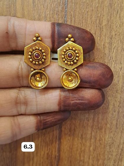 Another look at the hexagonal antique gold-plated earrings with a bowl-shaped drop. The craftsmanship gives them a high-quality, handmade feel.