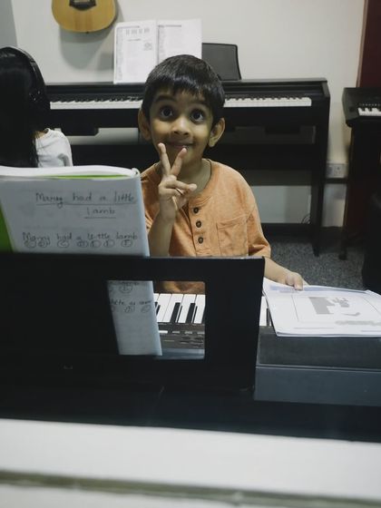 A young student proudly showing his sheet music for "Mary Had a Little Lamb". We celebrate every small victory on the path to learning an instrument.