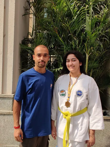 Posing with a student and her medal. Her hard work in training paid off, and I couldn't be prouder of her achievement.