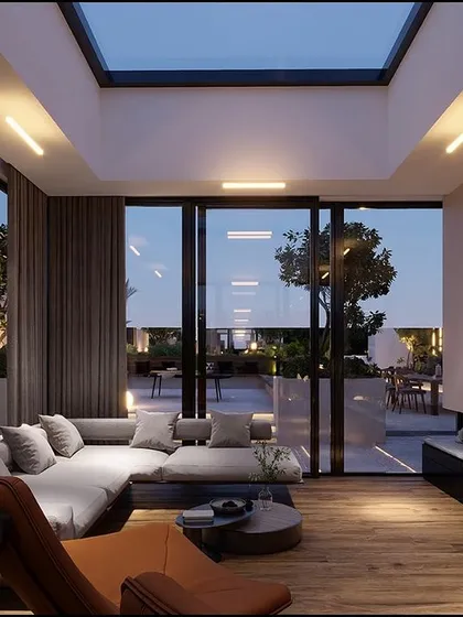 This image demonstrates the seamless indoor-outdoor living we create. Featuring a skylight and a modern fireplace, the living area flows directly onto the terrace, blurring the lines between the home's interior and the outdoor space.