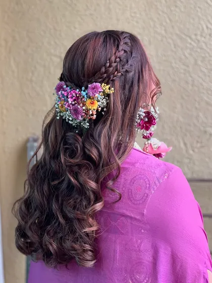 A side view of the intricate floral hairstyle, showing the combination of braids and fresh flowers.