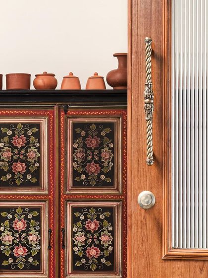 A detailed shot of the hand-painted vintage cabinet, a treasured find that adds immense character and a story to the dining space.