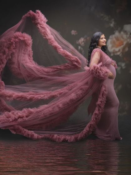 A symphony of motherhood and magic. This breathtaking image captures the soft elegance of her pink gown flowing like a gentle breeze, representing beauty and strength.