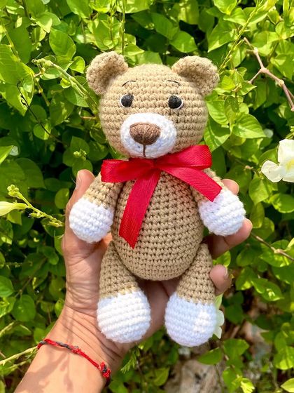 A classic teddy bear, a timeless gift for any age. This one is shown with a red ribbon, a black tie for 'Daddy Bear', and with expressive green eyes. They are soft, cuddly, and made to be loved.
