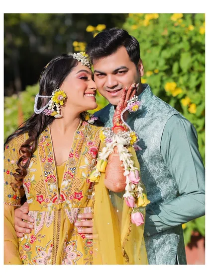 A tender moment from a Haldi ceremony, where the bride's floral jewelry and the couple's loving embrace are the focus. We capture these small, intimate gestures that make the day special.