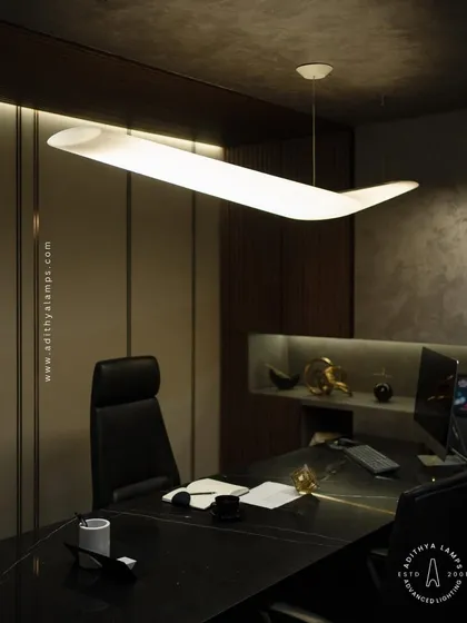 This uniquely shaped, wing-like pendant light provides excellent, broad illumination for this executive office. Its sculptural form makes it a statement piece, suitable for boardrooms and dining areas where design is paramount.