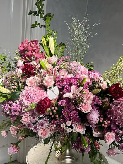 A breathtaking composition of plums and pinks. This grand arrangement combines the deep tones of burgundy with soft pink hydrangeas, lilies, and peonies for a look that is both romantic and incredibly sophisticated.