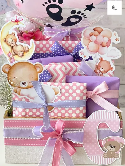 A detailed shot of the personalized hamper for baby Gaia, showcasing the cute teddy bear motifs and the carefully coordinated pink and purple wrapping.