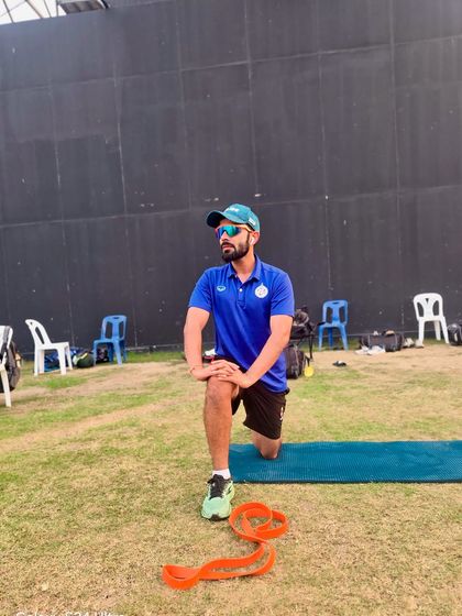 Taking a moment during a warm-up routine on the field. A proper warm-up, including dynamic stretches like this hip flexor lunge, is non-negotiable for preparing the body for intense activity and reducing injury risk.